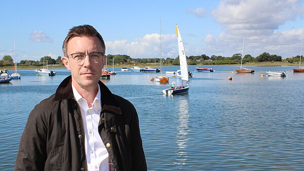 Candidate standing by a lake